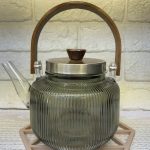 قوری پیرکس دودی با در و دسته چوبی فریم استیل مدل راه راه – ۸۵۰ میلی‌لیتر 🍵